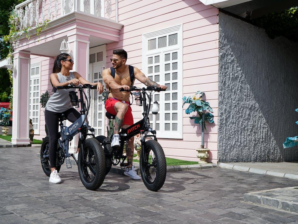 Free Man and Woman Riding Electric Bikes Stock Photo