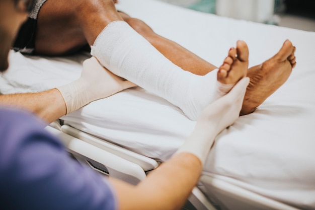 Free photo doctor helping a patient with a fractured leg