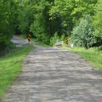 A graded gravel road leading to a small bridge in rural Virginia