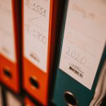 Labeled binders of office records on a shelf