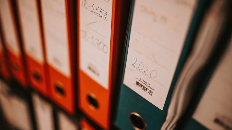 Labeled binders of office records on a shelf