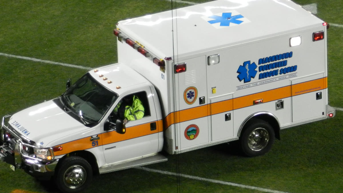A volunteer rescue squad ambulance driving onto a field