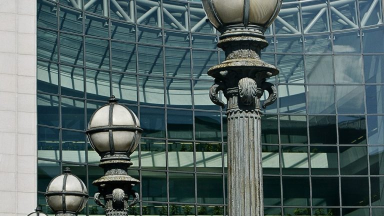 Ornate street lamps in front of the curved glass facade of the SEC headquarters