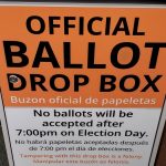 Orange and white official ballot drop box sign stating no ballots will be accepted after 7 p.m. on Election Day