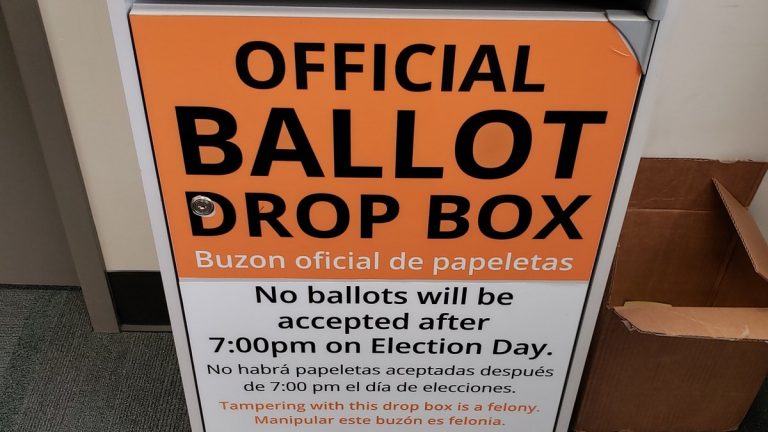 Orange and white official ballot drop box sign stating no ballots will be accepted after 7 p.m. on Election Day