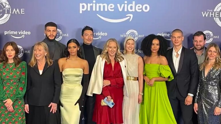 Cast and crew of The Wheel of Time posing in front of a Prime Video backdrop at the London premiere